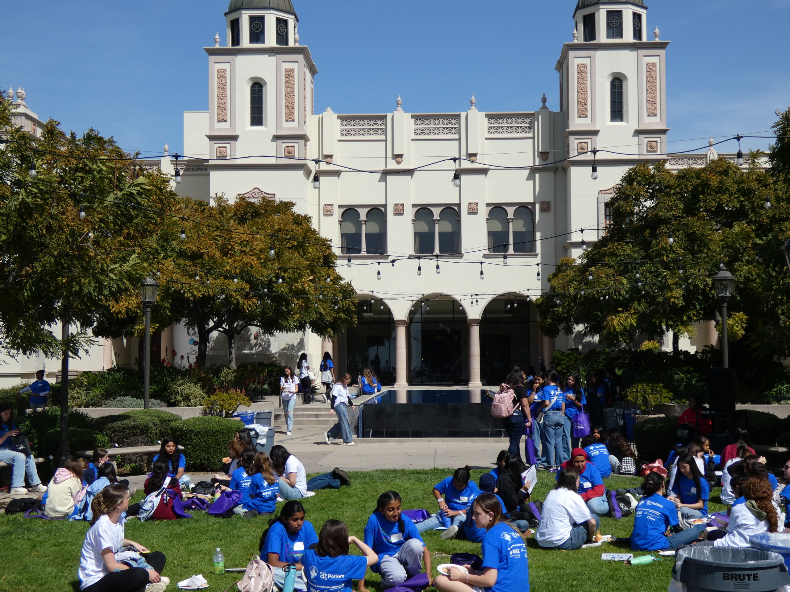 A campus with many students hanging out on the grounds in matching T-shirts.